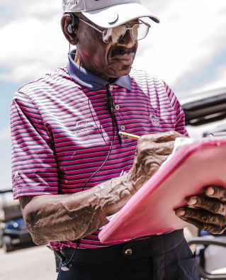 Man Wearing White Cap and Holding Printer Paper and Pen